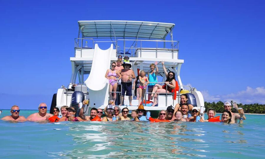 Punta Cana: Catamaran Tour with Reef Snorkeling and Open Bar - Boarding a spacious boat with a social mood
